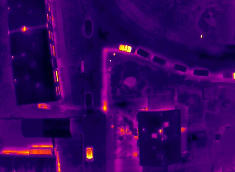 Drohneninspektion und Luftaufnahme einer Fernwärmeleitung, die Leckagen per Drohnen-Thermografie aufzeigt