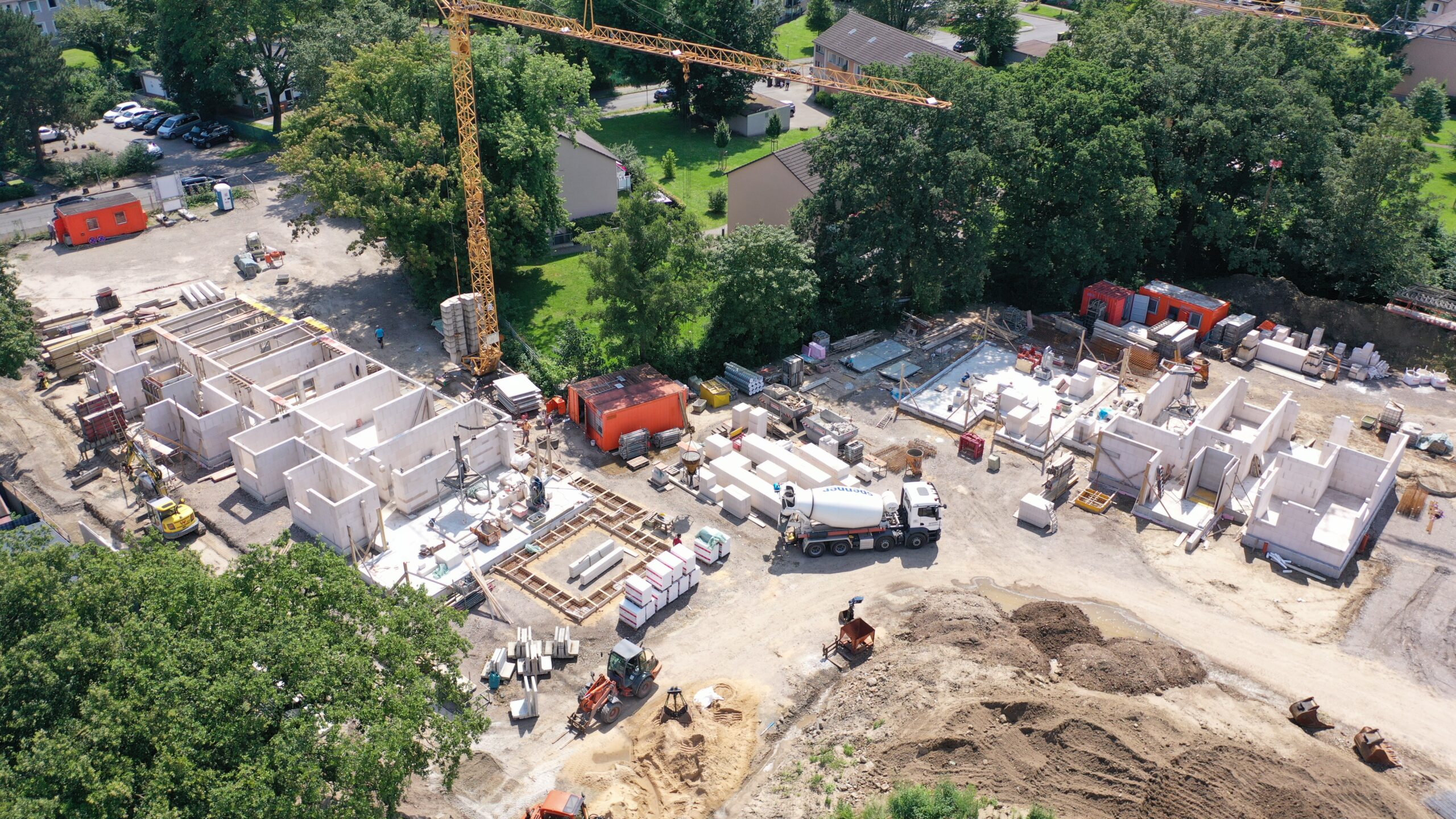 Luftaufnahme einer Baustelle mit Kran und Rohbauten, per Drohne aufgenommen