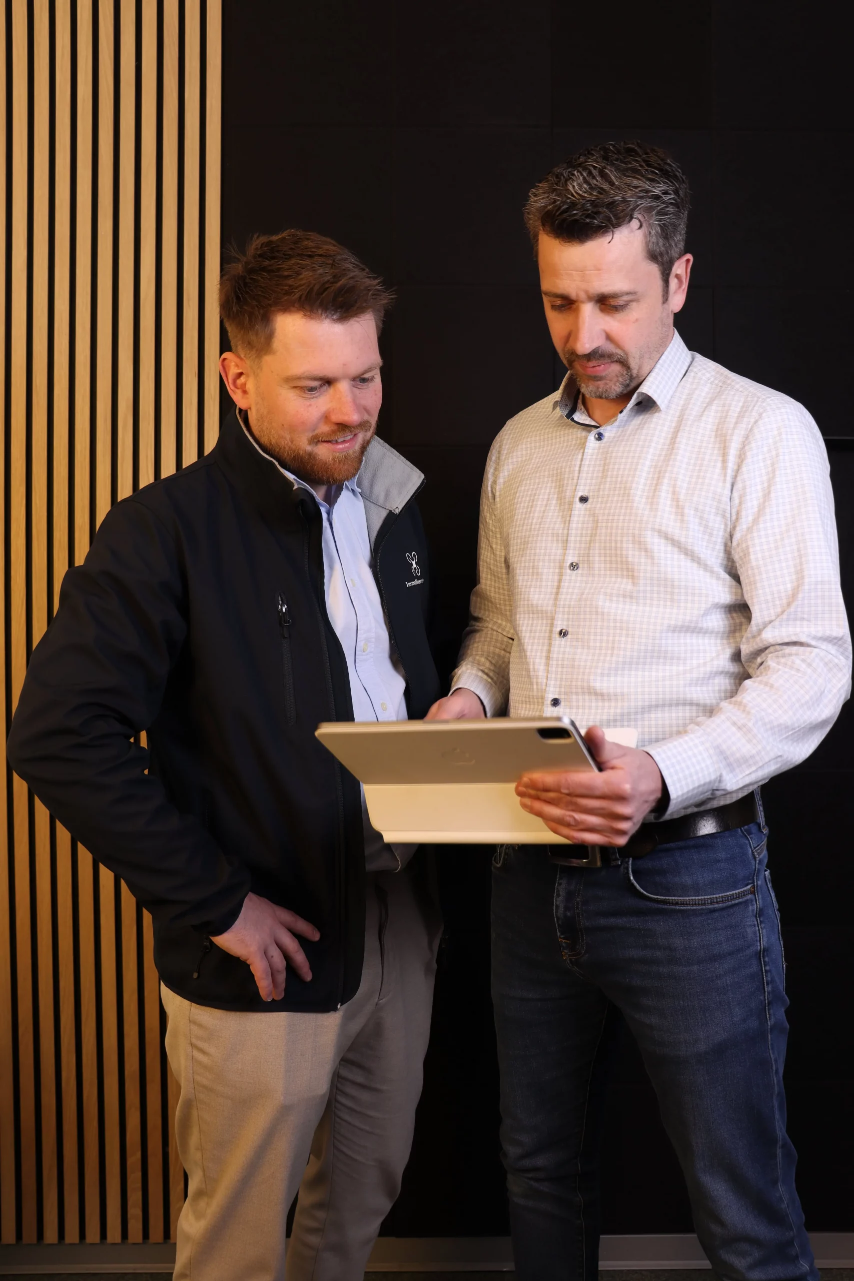 Fabian Tittgen und Rico Kossik von Immo-Drohnenservice prüfen Drohnenaufnahmen am Tablet